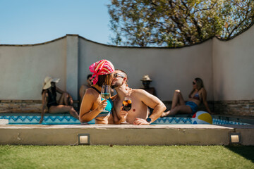 a latin engaged couple kissing inside a swimming pool