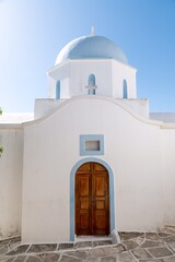 Photo of a typical white washed Greek orthodox church with pale blue dome on the island of Paros.