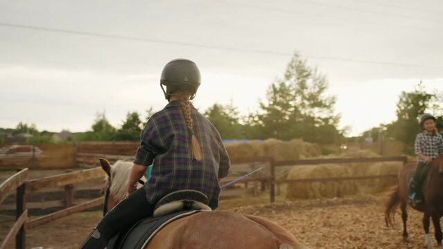 children are learning horseback riding in pony club, little girl is riding horse, lesson in paddock