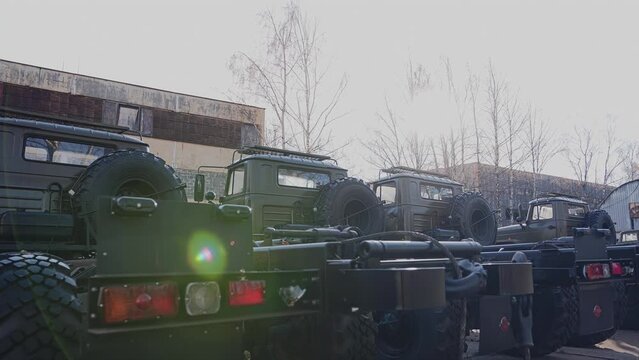 A row of military equipment standing in the parking lot. Shooting military trucks