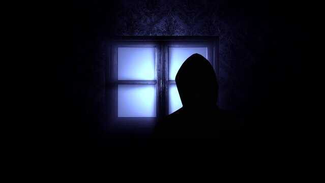 Shadowy figure moves across a brightly lit window