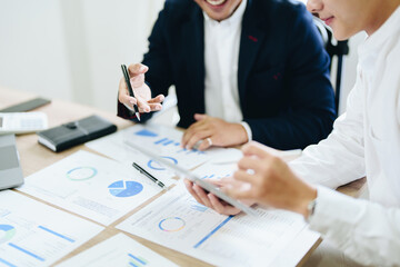 Fototapeta premium Concept of the impact of warring countries, male economists are using tablets to consult with marketing staff or accountants to adjust production and investment strategies to the current situation.