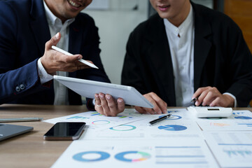 Concept of the impact of warring countries, male economists are using tablets to consult with marketing staff or accountants to adjust production and investment strategies to the current situation