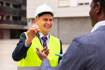 Happy builder gives the keys to the new home african american businessman