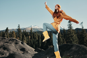 Woman smile with teeth happiness and laughter hiker in yellow raincoat put her hands up and jumping...