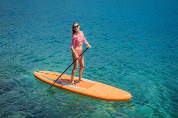 Young women Having Fun Stand Up Paddling in blue water sea in Montenegro. SUP. girl Training on Paddle Board near the rocks Portrait of a disgruntled girl sitting at a cafe table