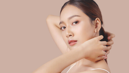 Studio shot of Beautiful young Asian woman with clean fresh skin on brown background, Face care,...