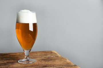 Glass of tasty beer on wooden table. Space for text