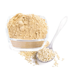 Sesame flour in glass bowl and spoon of seeds isolated on white