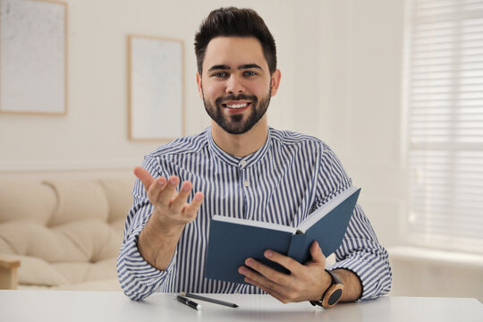 Young Man Conducting Webinar At Desk In Room