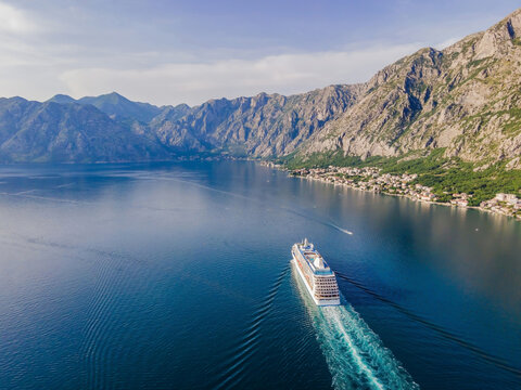 Luxury Passenger Liner In The Bay Of Kotor With Travel Returning After The Covid 19 Pandemic Portrait Of A Disgruntled Girl Sitting At A Cafe Table