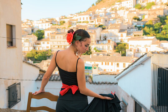 Woman dances flamenco with a Spanish town in the background