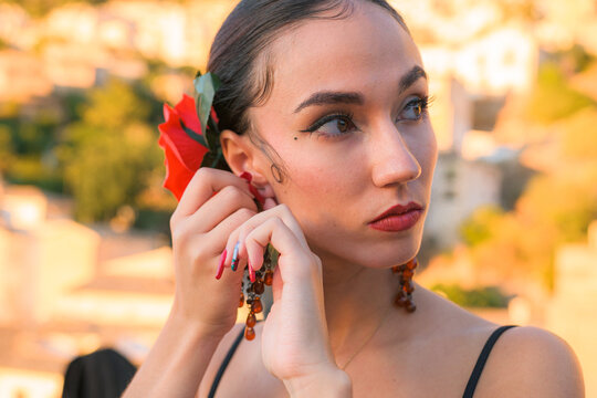 Woman puts an earring in her ear. Flamenco style