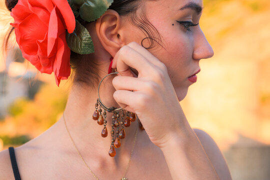 Woman puts an earring in her ear. Flamenco style