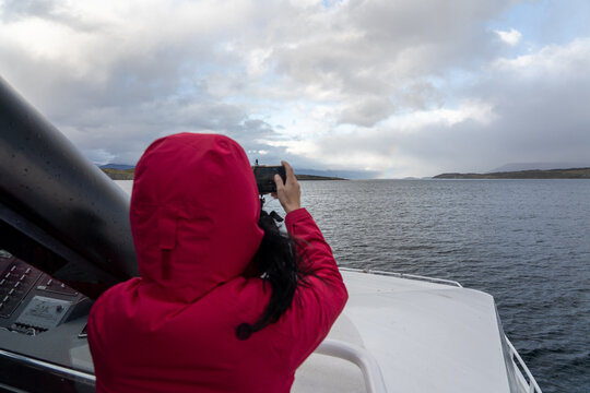 woman taking pictures and sailing throught the beagle channel