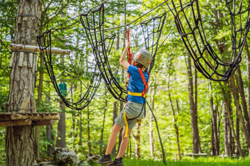 Happy child in a helmet, healthy teenager school boy enjoying activity in a climbing adventure park on a summer day Portrait of a disgruntled girl sitting at a cafe table