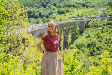Montenegro. Woman tourist in background of Dzhurdzhevich Bridge Over The River Tara. Travel around...