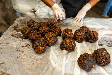 Unrecognizable Latino worker packing tamarind balls using hygiene measures like disposable gloves