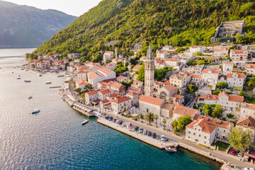 Fototapeta na wymiar Scenic panorama view of the historic town of Perast at famous Bay of Kotor with blooming flowers on a beautiful sunny day with blue sky and clouds in summer, Montenegro, southern Europe Portrait of a