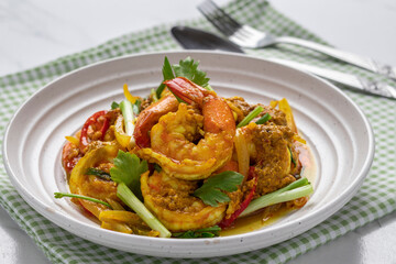 Shrimps stir fried with curry power, vegetables, herbs and spices like garlic, onion, pepper, chili, scallion and celery. It is a popular seafood dish popularly served in Thai seafood restaurants.