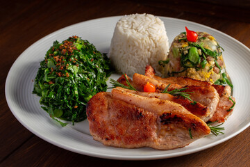 Pork loin with beans (Feijão Tropeiro), rice and cabbage. Brazilian traditional dish