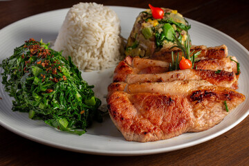 Pork loin with beans (Feijão Tropeiro), rice and cabbage. Brazilian traditional dish
