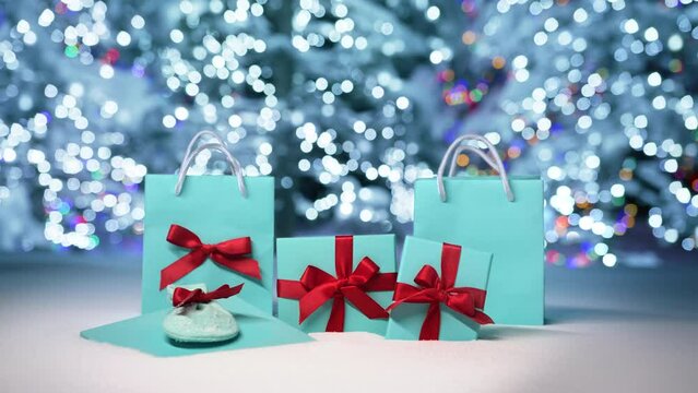 Merry Christmas eve background footage 6K. Shiny blue silver lights on Christmas trees glittering and sparkling in blurry background. New Year 2023 background elegant blue gift boxes with red ribbons