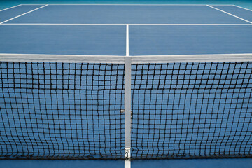Horizontal high angle no people conceptual shot of modern tennis court with blue floor and net, copy space