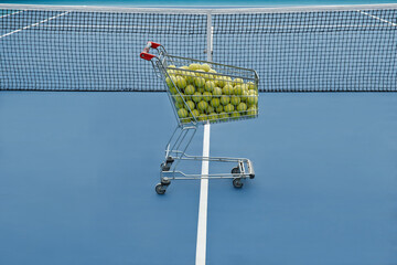 Horizontal no people high angle shot of trolley full of tennis balls and net in court, professional sport concept, copy space