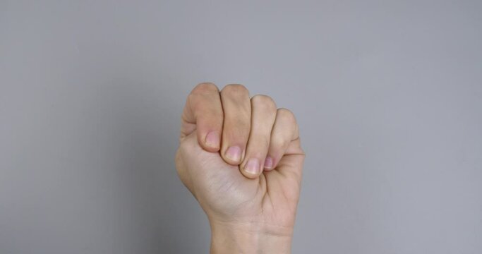 hand ask for help international symbol closeup on gray background. High quality 4k footage