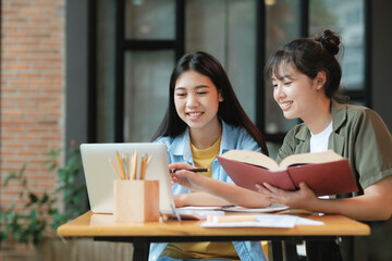Young asian students campus helps friend catching up and learning.