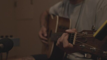 Man Playing Guitar in Recording Studio Booth