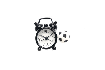 A picture of alarm clock and miniature ball. Football time concept.