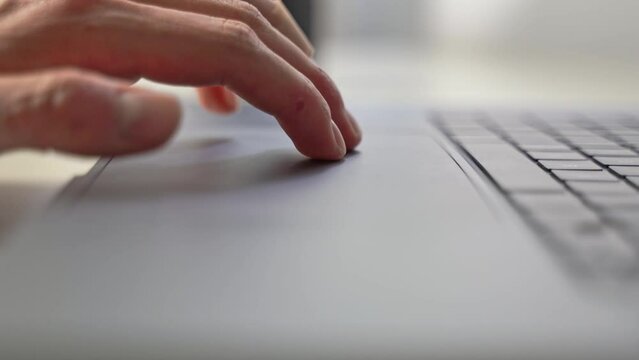 Hands patiently use the computer laptop touchpad to guide a gaming character around the video game