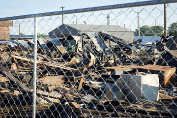 Debris and rubble of destroyed urban building behind fence
