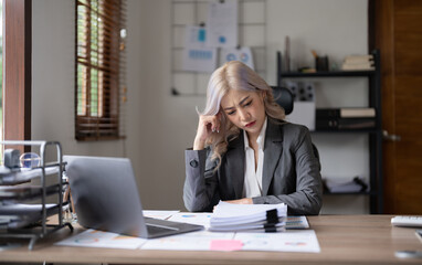 Obraz premium Bored Workaholic Accountant Employee With Headache. stressed working woman at business desk in a business office