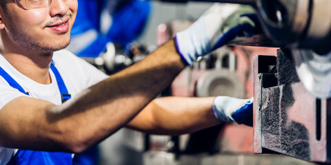 Professional labor machanic engineer technician worker industrial man wearing blue safety uniform working control with heavy machine in manufacturing  factory production line.business industry