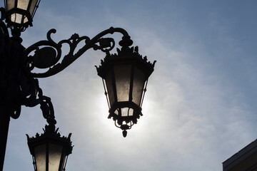 Fototapeta na wymiar classic old street lamp backlit silhouette during daytime