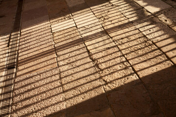 light and shadow pattern on stone ground, bars, jail, traped