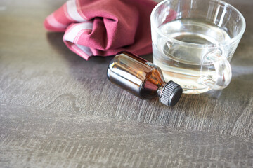 A bottle of sedative is on the table next to the handkerchief and a mug of water. The concept is...