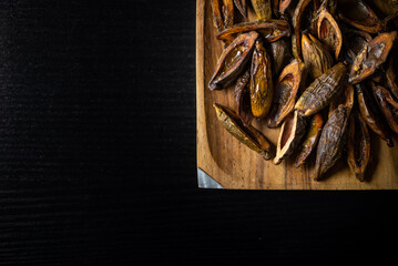 Betel nuts in a plate close-up top view on a black table