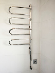 The electric towel warmer is unplugged from the socket. Saving energy resources.