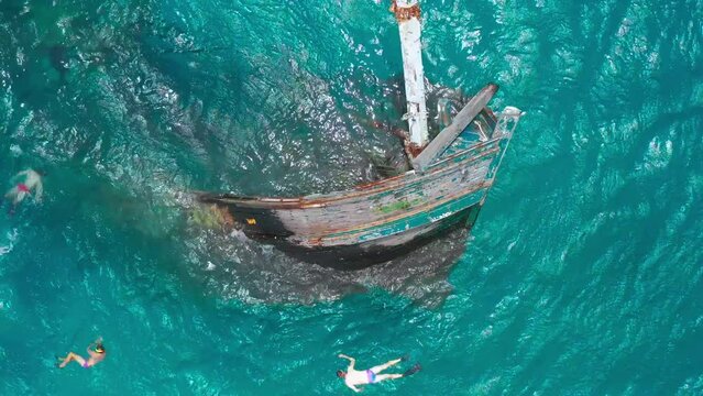 Aerial view on Sunken Ship Prow with people snorkeling. Shipwreck in Vaavu Atoll near Keyodhoo Island, Maldives.