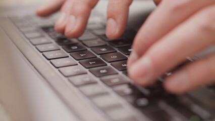 Close up macro of hands typing on laptop keyboard mac computer