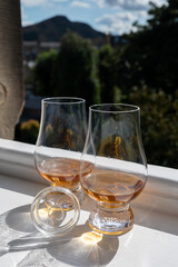 Two glasses of single malt scotch whisky served on old window sill in Scottisch house with view on old part of Edinburgh, Scotland, UK