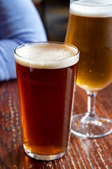 Pint glasses of british ale and lager beer served in old vintage English pub
