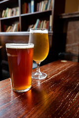 Pint glasses of british ale and lager beer served in old vintage English pub
