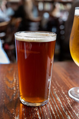 Pint glass of british golden ale or ipa beer served in old vintage English pub