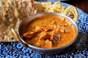 Indian style food, chiken tikka masala curry dish served with rice and garlic bread naan