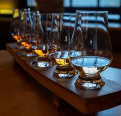 Flight of single malt scotch whisky in glasses served in whiskey bar in Edinburgh, UK